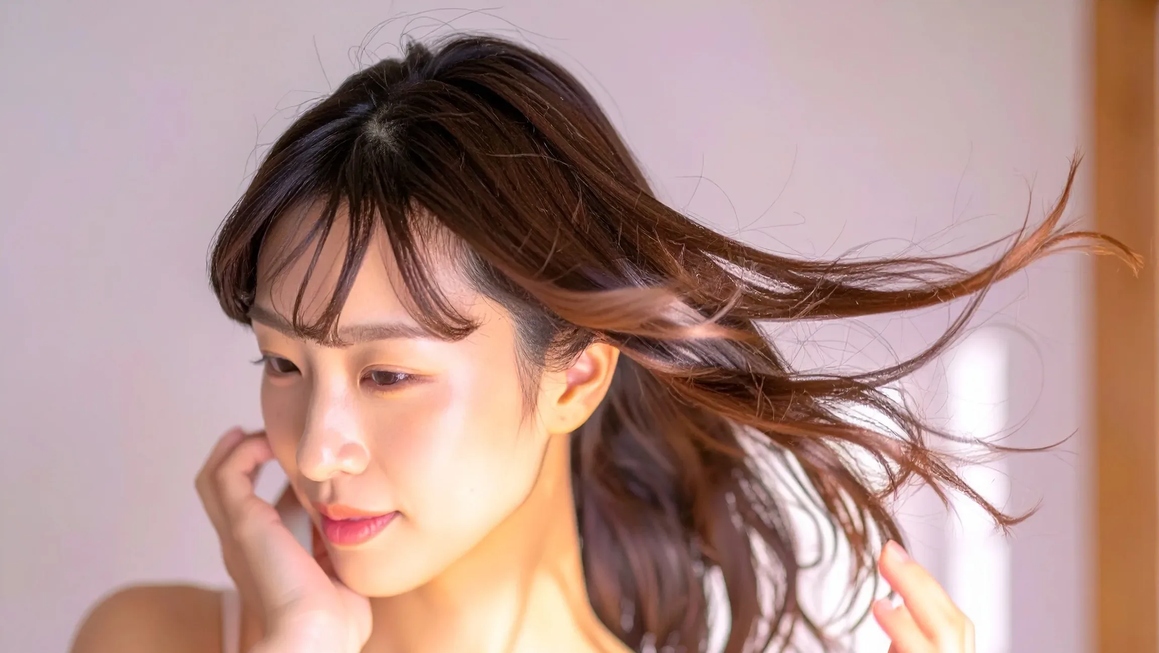 風に髪がなびいている女性